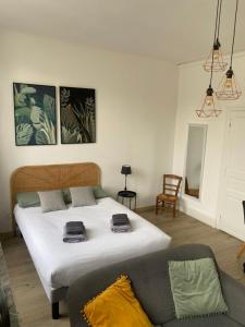 1 dormitorio con 1 cama grande y 1 sofá en Le Studio de Meli, 3 étoiles, 30m2, raffiné, élégant et bien situé, en Rochefort