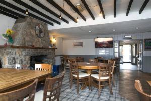 a restaurant with tables and chairs and a fireplace at Pass the Keys Modern en-suite room in country PubRestaurant 4 in Llanddona
