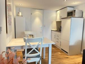 提努姆的住宿－Lüttes Tohuus，厨房配有白色桌子和白色冰箱。