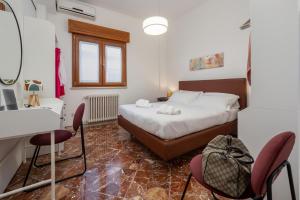 Un dormitorio con una cama y una mesa y sillas. en Rossella Holiday Home, en Sorrento
