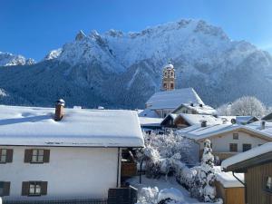 a snow covered village with a mountain in the background at Haus Heimatfrieden Mittenwald in Mittenwald