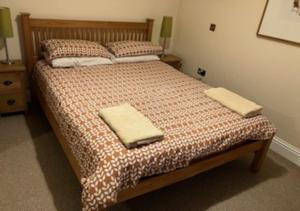 een slaapkamer met een bed met twee handdoeken erop bij Inglenook Cottage in Wandylaw