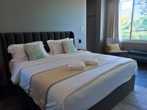 a large bed with two towels on top of it at New Chapter House, 3 big bedroom, 1.5 km to centre in Pai