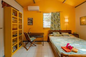 a bedroom with a bed and a desk at Kaz Zen in Sainte-Anne