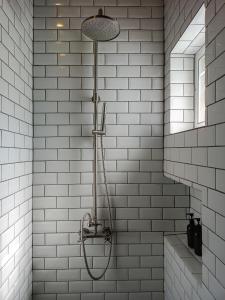 a shower in a bathroom with white subway tiles at New Chapter House, 3 big bedroom, 1.5 km to centre in Pai