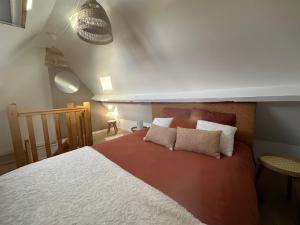 een slaapkamer met een groot bed met kussens erop bij Coup de cœur~Duplex cocoon vue sur le beffroi -Top Séjour Arras in Arras