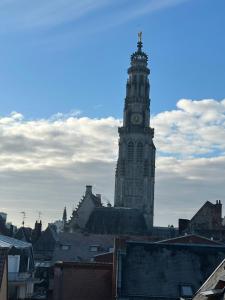 een hoge klokkentoren met een klok erop bij Coup de cœur~Duplex cocoon vue sur le beffroi -Top Séjour Arras in Arras