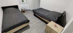 two twin beds in a room with a wooden floor at Appartement en centre ville in Thonon-les-Bains