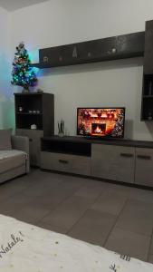 a living room with a television and a christmas tree at House Arrow in Latina