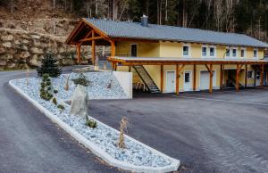 a large yellow building with a house at Ferienwohnung Sabine in Flattach