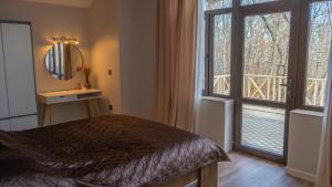 a bedroom with a bed and a mirror and a window at CHALET WOODS GUSAR in Qusar