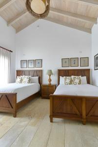 a bedroom with two beds and a mirror at Majestuosa villa en Juan Dolio, Guavaberry Golf & Country Club in Juan Dolio