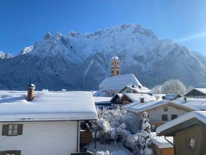 una ciudad nevada con una montaña en el fondo en Haus Heimatfrieden Mittenwald, en Mittenwald
