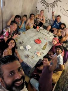 Un groupe de personnes assises autour d'une table dans l'établissement Dreamcatcher House & Hostel at Arambol Beach, à Arambol