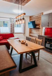 a kitchen with a wooden table and a red couch at Ferienwohnung Sabine in Flattach