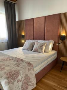 um quarto com uma cama grande e uma cabeceira em madeira em Къща за гости Лиственица 1 em Banya