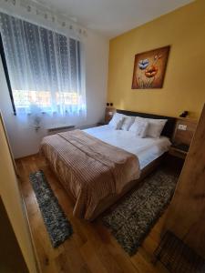 - une chambre avec un grand lit et une fenêtre dans l'établissement Apartman Rajska dolina Titova vila, à Palisat