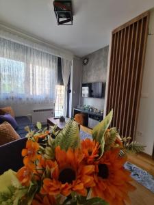 - un salon avec un vase de fleurs sur une table dans l'établissement Apartman Rajska dolina Titova vila, à Palisat