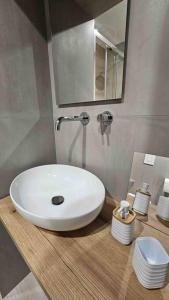 La salle de bains est pourvue d'un lavabo blanc et de toilettes. dans l'établissement Scala Paradiso ~ B&B Molfetta, à Molfetta