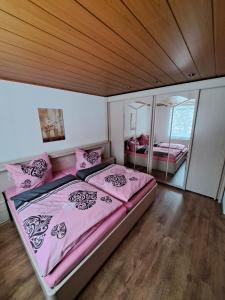a bedroom with a large bed with pink sheets at Ferienwohnung Böhmischerblick in Bärenstein