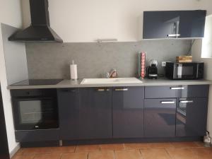 a kitchen with a sink and a microwave at Maison à 500 m du lac in Ardres