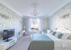 ein Schlafzimmer mit einem Bett und einem TV. in der Unterkunft Palais Miramar Imperial Croisette in Cannes