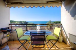 patio con mesa y sillas en el balcón en 06AY - Studio with seafront terrace, en Antibes