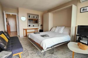 um quarto com uma cama e uma sala de estar em 06AY - Studio with seafront terrace em Antibes