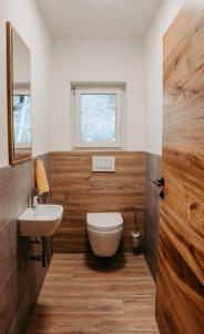 ein Bad mit einem WC, einem Waschbecken und einem Fenster in der Unterkunft Ferienwohnung Sabine in Flattach