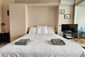 1 dormitorio con 1 cama blanca grande y toallas. en 06AY - Studio with seafront terrace, en Antibes