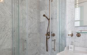 La salle de bains est pourvue d'une douche avec une porte en verre. dans l'établissement Jordaan Suite bed and bubbles, à Amsterdam