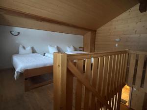 1 dormitorio con 1 cama y una escalera en una cabaña en L'Auberge de L'Ours, en Vers L'Eglise