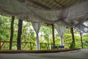 Portal del Sol في فيلاجارزون: غرفة مع ستائر بيضاء وكرسيين زرق