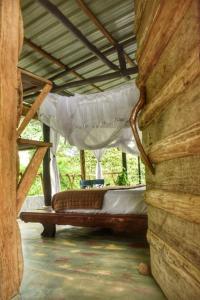 Portal del Sol في فيلاجارزون: شرفة مع سرير في منزل خشبي