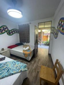 ein Schlafzimmer mit zwei Betten und einem Tisch und einem Stuhl in der Unterkunft Casa Josep H'i in Sololá