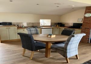a kitchen with a wooden table and two chairs at Outlook Cottage in Wandylaw