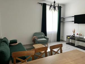 a living room with a green couch and chairs at DOWNTOWN APPARTMENTS in Karagandy