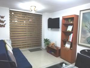 a living room with a large wooden wall at Apto. acogedor cerca de todo lo mejor de la ciudad in Manizales