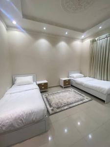 Dieses weiße Zimmer verfügt über 2 Betten und ein Fenster. in der Unterkunft Entire apartment 2 bedrooms private entry Closeto digital city and KAFD in Riad