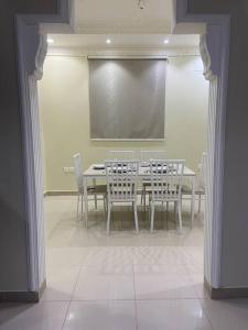 ein Esszimmer mit einem Tisch, Stühlen und einem Bildschirm in der Unterkunft Entire apartment 2 bedrooms private entry Closeto digital city and KAFD in Riad
