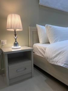 Bett mit Nachttisch mit Lampe in der Unterkunft Entire apartment 2 bedrooms private entry Closeto digital city and KAFD in Riad