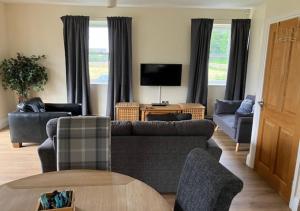 a living room with a couch and a tv at Outlook Cottage in Wandylaw