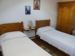 1 dormitorio con 2 camas y lámpara. en Pensiunea Casa Filoxenia en Horezu