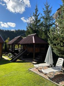 a gazebo with two chairs and a slide at Guest House Kaspiy in Bukovel