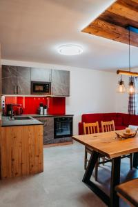 a kitchen with a wooden table and a red couch at Ferienwohnung Sabine in Flattach