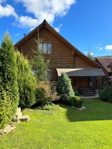 a log house with a yard in front of it at Guest House Kaspiy in Bukovel