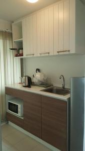 uma cozinha com um lavatório e um micro-ondas em Baan Thewlom em Cha Am