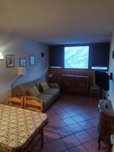 a living room with a couch and a tv at Val di Sole Holidays in Folgarida