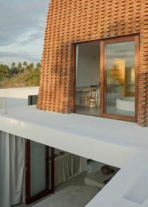einen Balkon mit Blick auf das Haus in der Unterkunft Casa Attico - Design Beach House in Touros