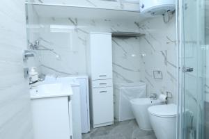 Baño blanco con aseo y lavamanos en Holiday Home Litteri, en Catania